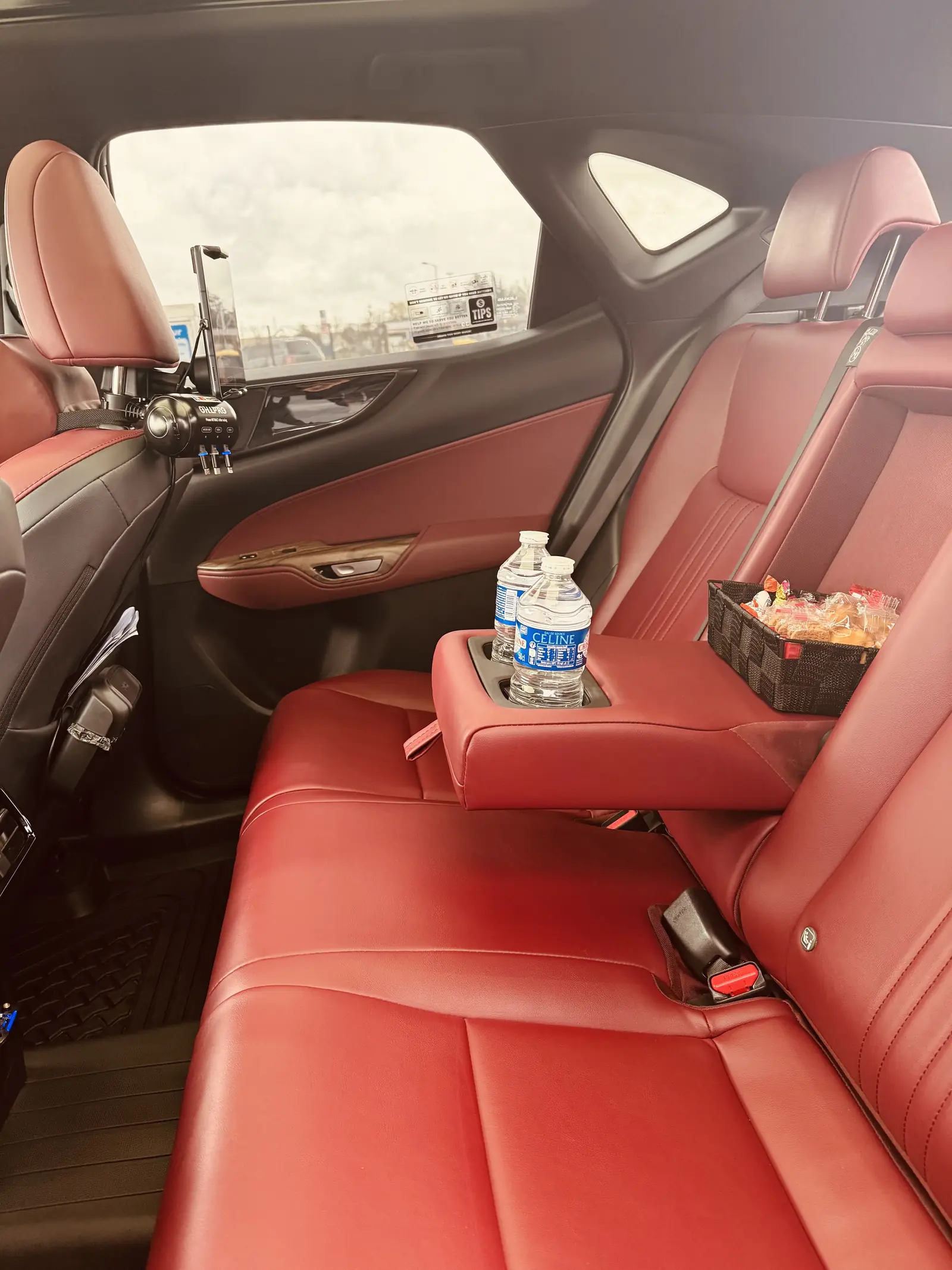 Banquette arrière en cuir rouge du taxi, avec bouteilles d'eau et confiseries à disposition des passagers