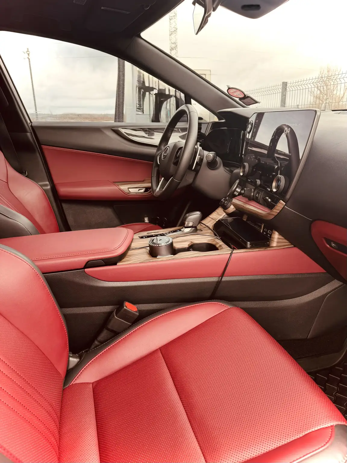 Poste de conduite du taxi VTC de Loyale Transport : sellerie cuir rouge, console centrale et écran tactile